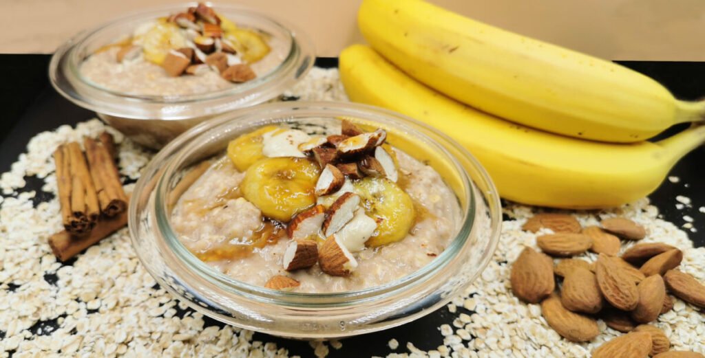 Crema de avena espesa coronada con rodajas de plátano dorado y almendras para Porridge de Avena