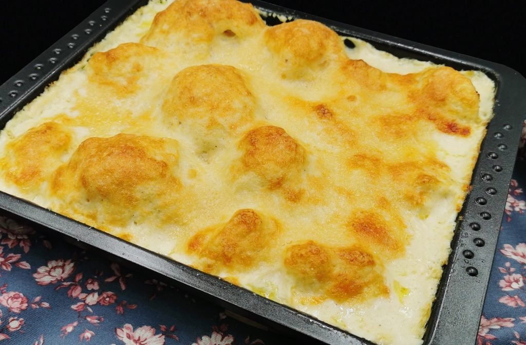 Floretes horneados bañados en salsa blanca cremosa con costra dorada para Coliflor con Salsa de Queso
