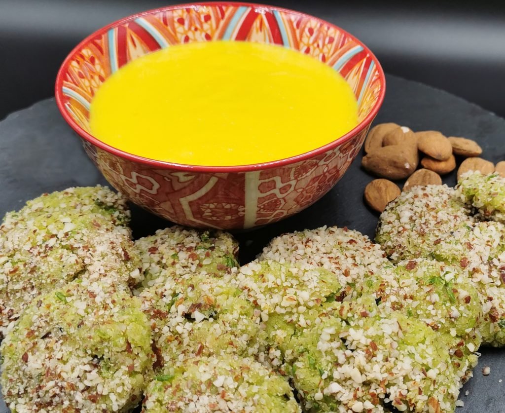 Bolitas doradas al horno servidas sobre salsa amarilla brillante de azafrán para Bocaditos de Tofu y Arvejas