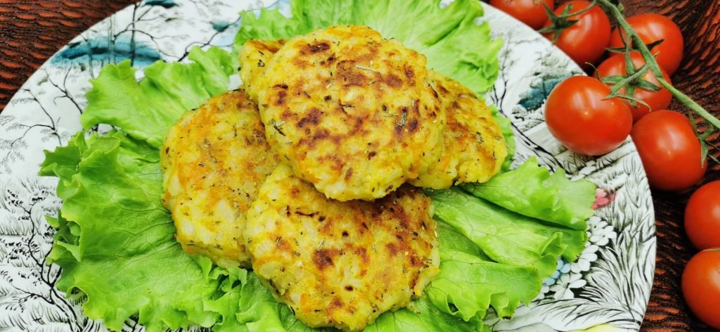 Medallones dorados y crujientes con trocitos de zanahoria y arroz visible para Hamburguesas de Papa