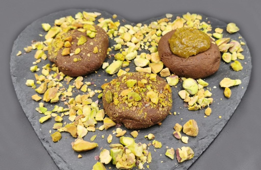 Galletas oscuras de cacao decoradas con trozos verdes y crema de fruto seco para Galletas de Chocolate