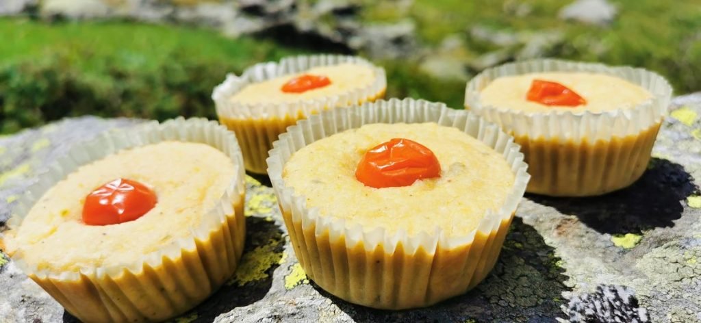 Panecillos horneados esponjosos coronados con un tomate rojo asado para Magdalenas Saladas