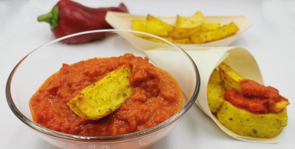 Salsa roja densa y brillante con trozos de pimiento confitado para Salsa Agridulce de Tomate