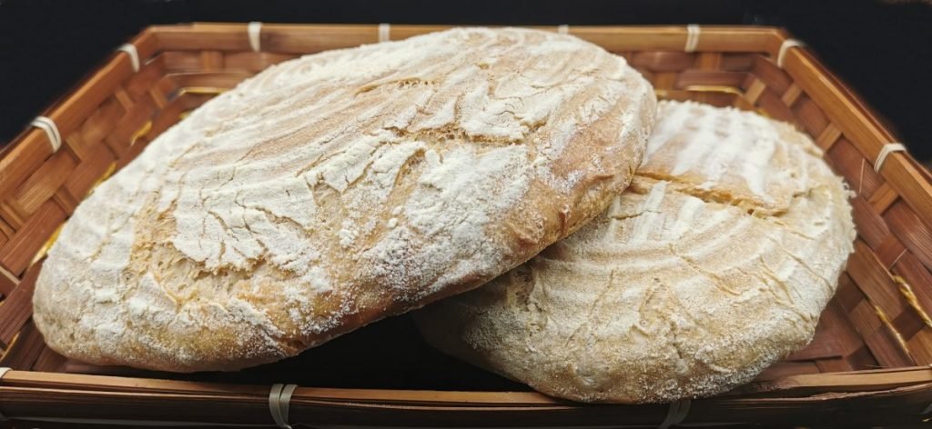 Hogaza rústica de corteza dorada y crujiente con superficie enharinada para Pan Casero