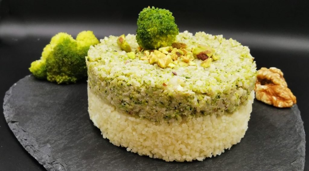 Granos sueltos servidos con crema verde brillante, floretes y pistachos para Cuscús con Crema de Brócoli