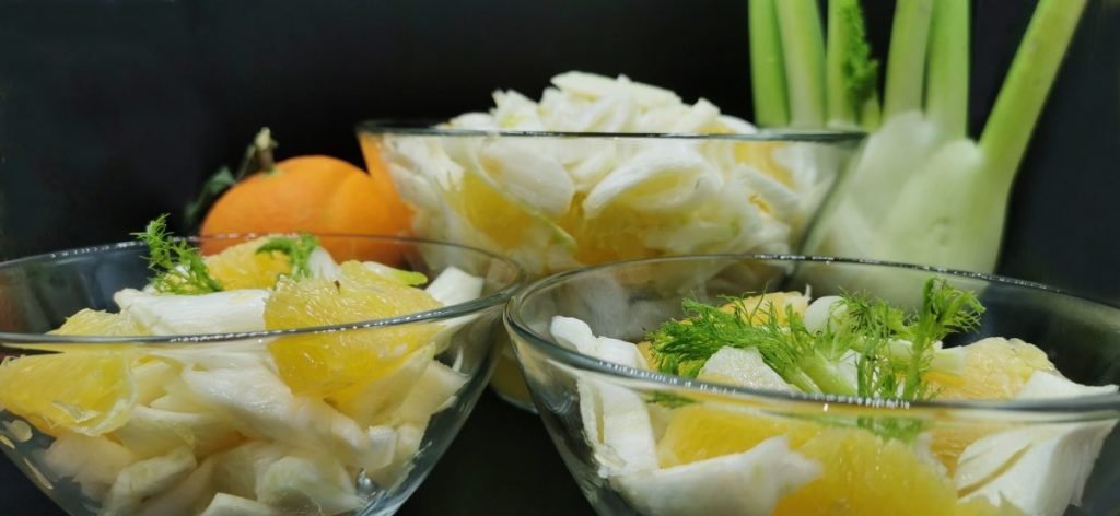 Plato fresco con gajos de cítricos brillantes y láminas blancas crujientes para Ensalada de Hinojo
