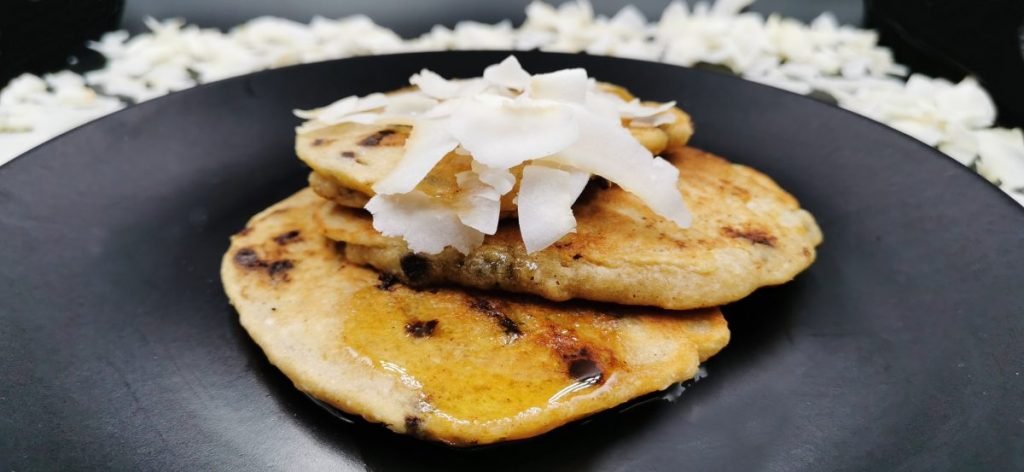 Torre de tortitas esponjosas y doradas con chispas de chocolate derretidas para Pancakes de Coco