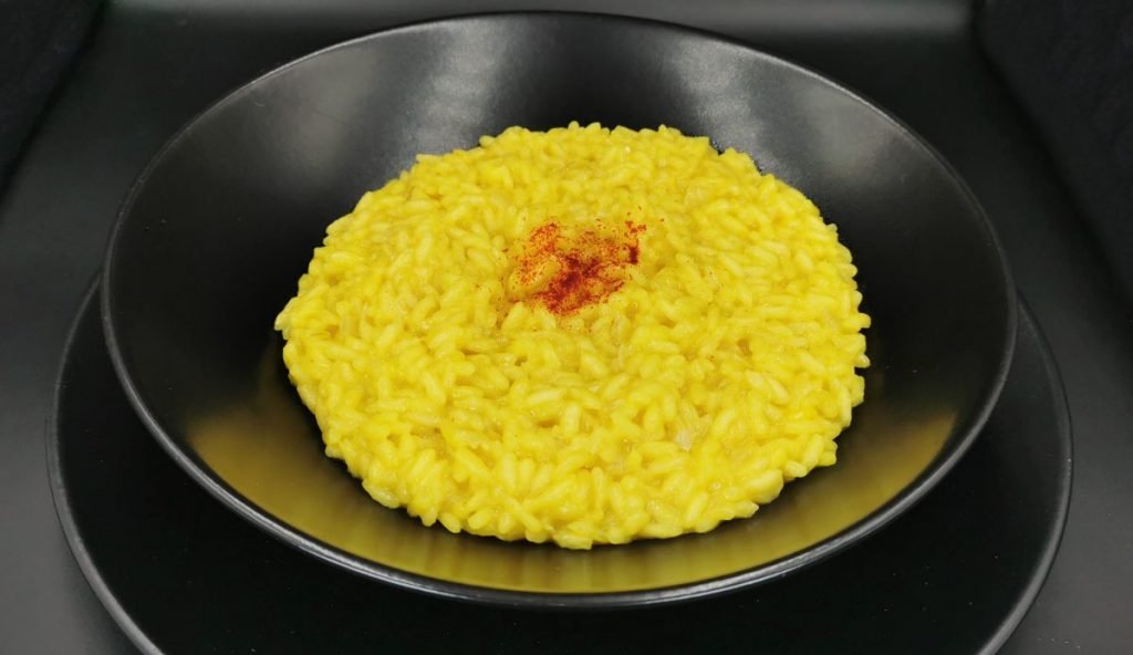 Arroz cremoso y brillante de color amarillo intenso con textura húmeda para Risotto al Azafrán
