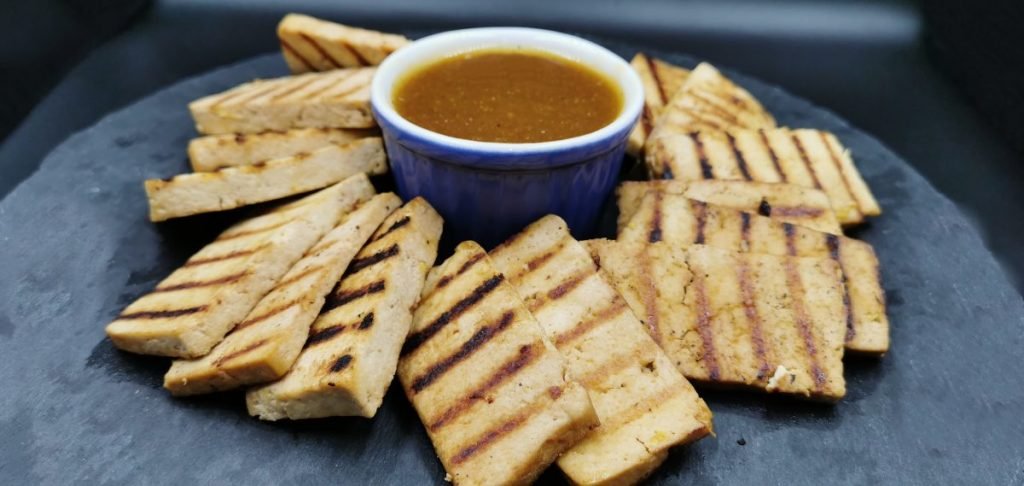 Rebanadas de tofu a la parrilla cubiertas con salsa brillante y espesa de cítricos para Tofu Marinado a la Naranja
