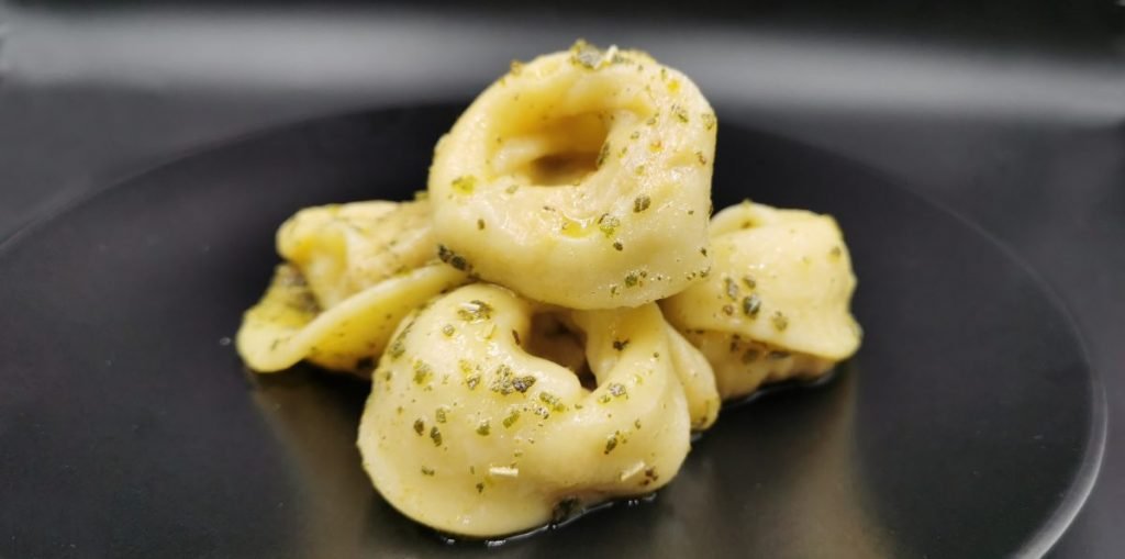 Pasta fresca rellena con forma de sombrero servida con salsa ligera para Cappelletti de Calabaza