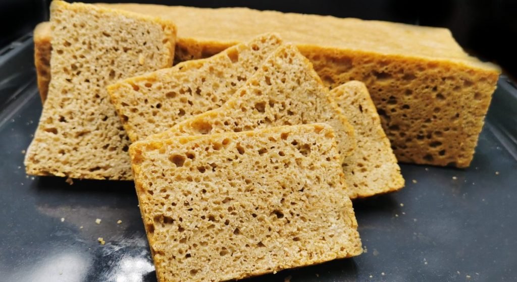 Pan de molde alto y oscuro con corteza firme y miga integral compacta para Pan Cuadrado de Granos