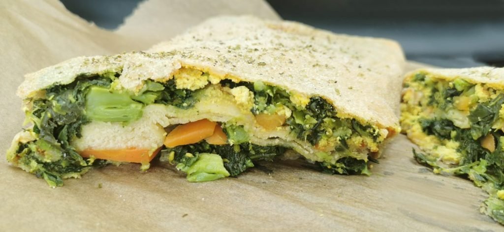 Pan plano dorado y crujiente relleno de hojas verdes y zanahorias tiernas para Schiacciata de Verduras