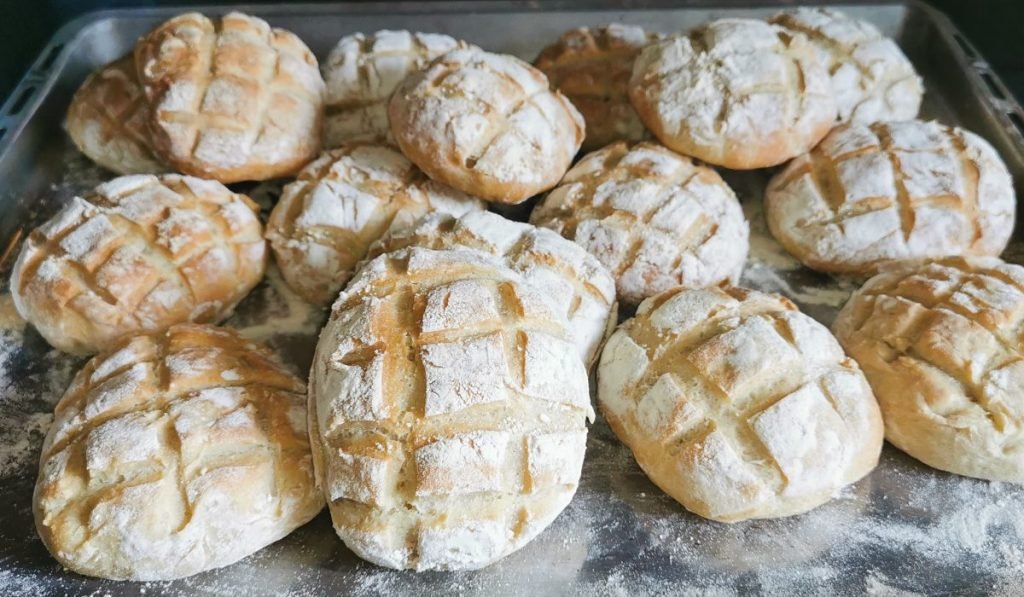 Panecillos horneados con corteza dorada y cortes en forma de caparazón para Pan Tortuga casero