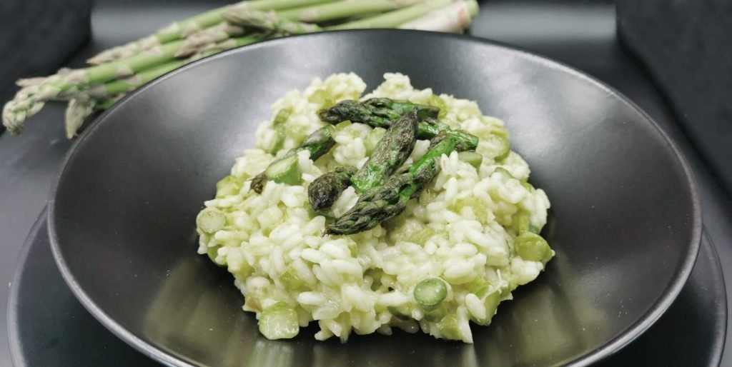 Arroz meloso y brillante decorado con puntas de espárragos verdes para Risotto con Espárragos