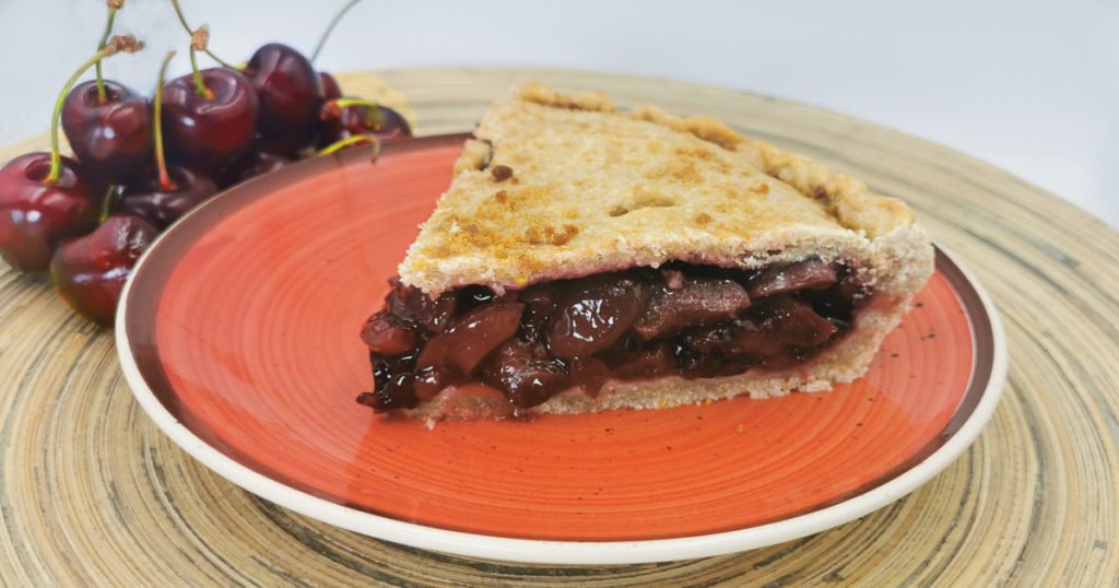 Tarta horneada de corteza dorada y crujiente con relleno de fruta roja jugosa para Pie de Cerezas