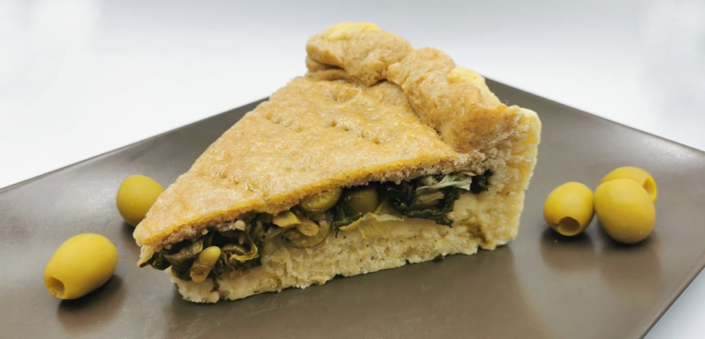 Pastel salado cerrado y dorado con relleno jugoso de escarola y aceitunas para Pizza Rellena de Escarola