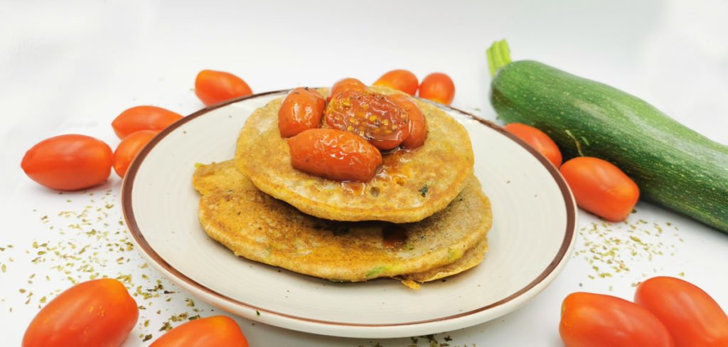 Torre de tortitas esponjosas y doradas con trocitos verdes de calabacín para Pancakes Salados de Calabacines
