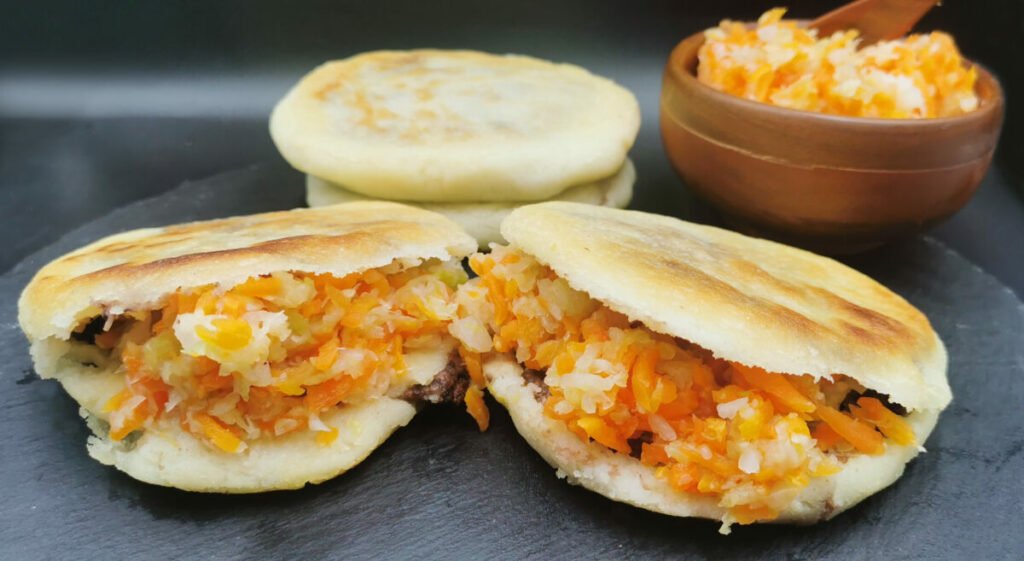Tortillas de maíz gruesas y doradas a la plancha acompañadas de repollo para Pupusas Vegetarianas