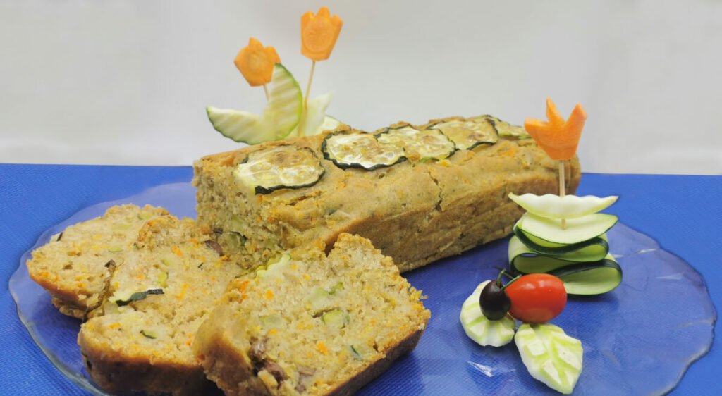 Bizcocho salado dorado con trozos de zanahoria y rodajas de calabacín para Pastel Salado de Verduras