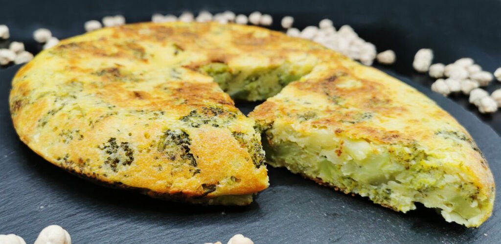 Tortilla gruesa y dorada a base de harina de garbanzos con trozos verdes de brócoli para Tortilla Vegana