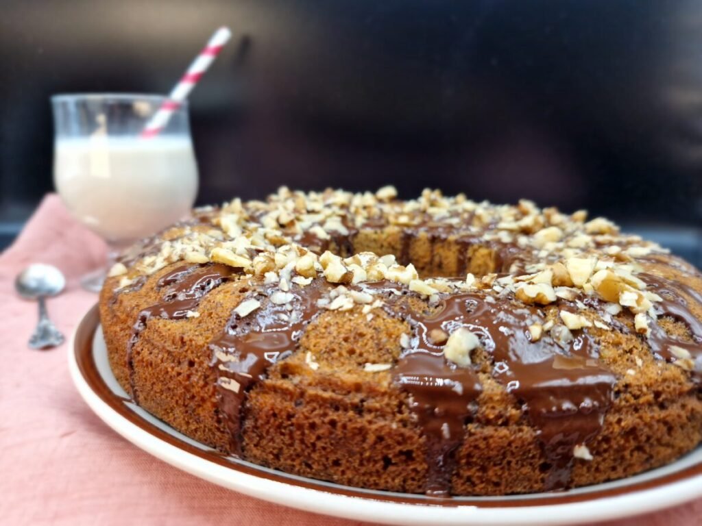 Pastel húmedo y dorado cubierto con chocolate negro derretido y almendras troceadas para Pastel de Zanahoria